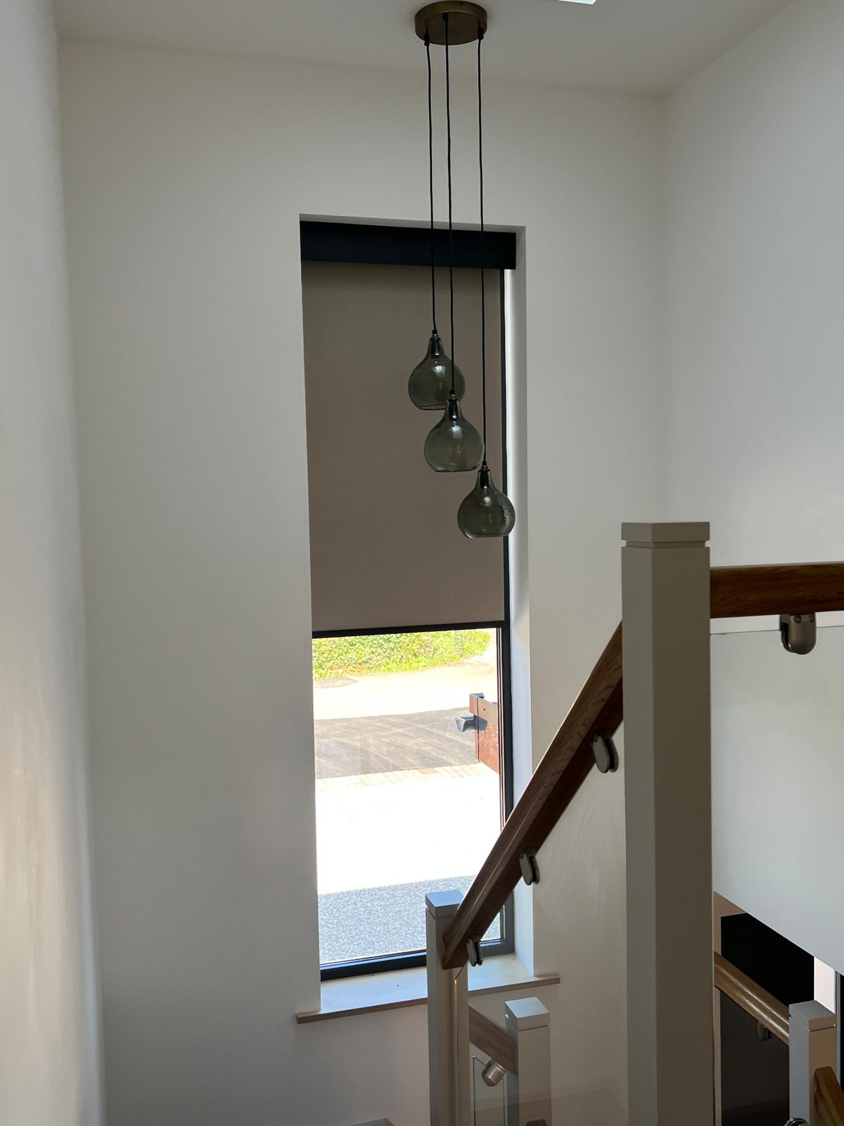 Tall narrow stairwell window fitted with a light roller blind