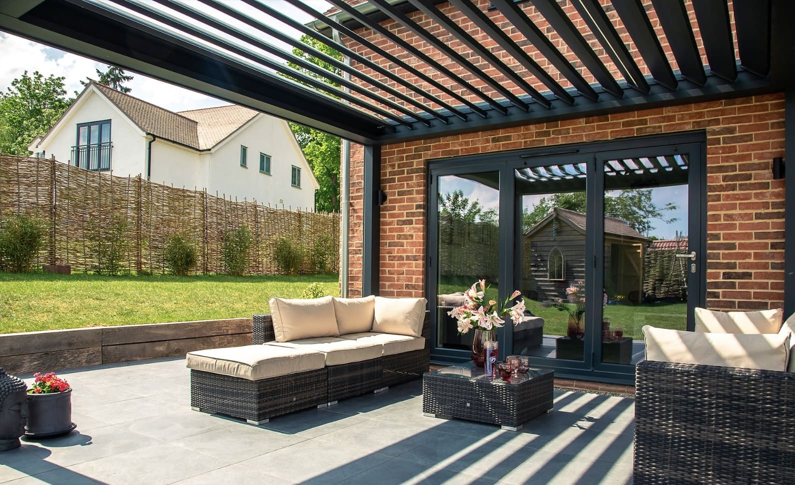 Daytime pergola attached to a brick house with bi-fold doors