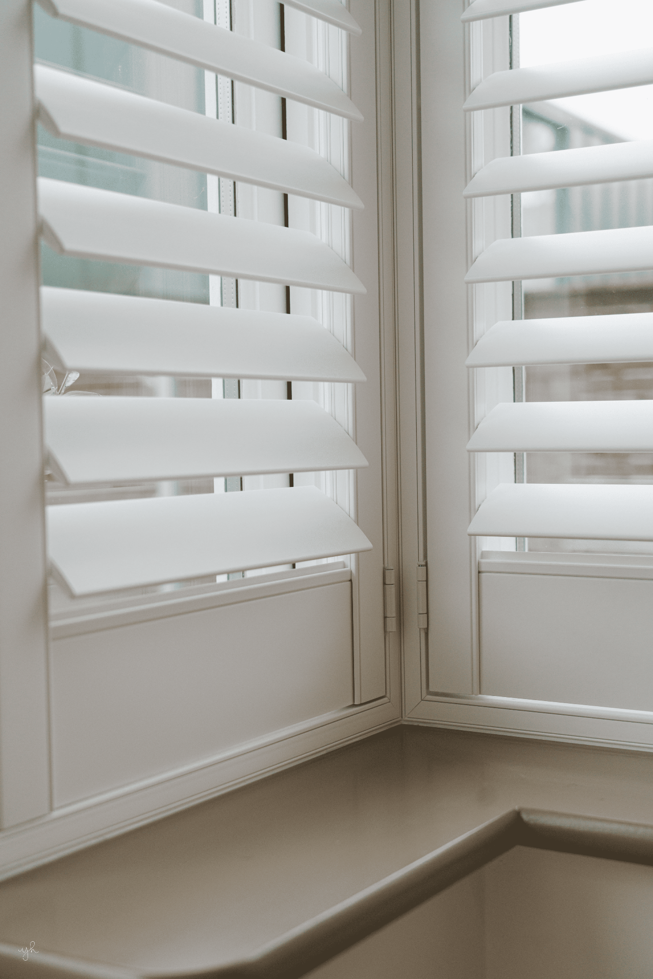 Corner hinge detail of white plantation shutters