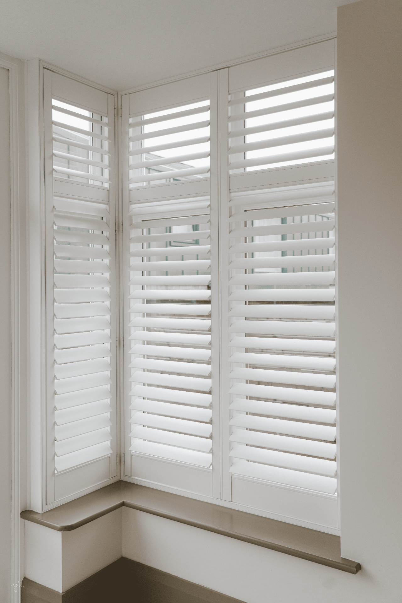 White corner bay shutters fitted in a bright contemporary home